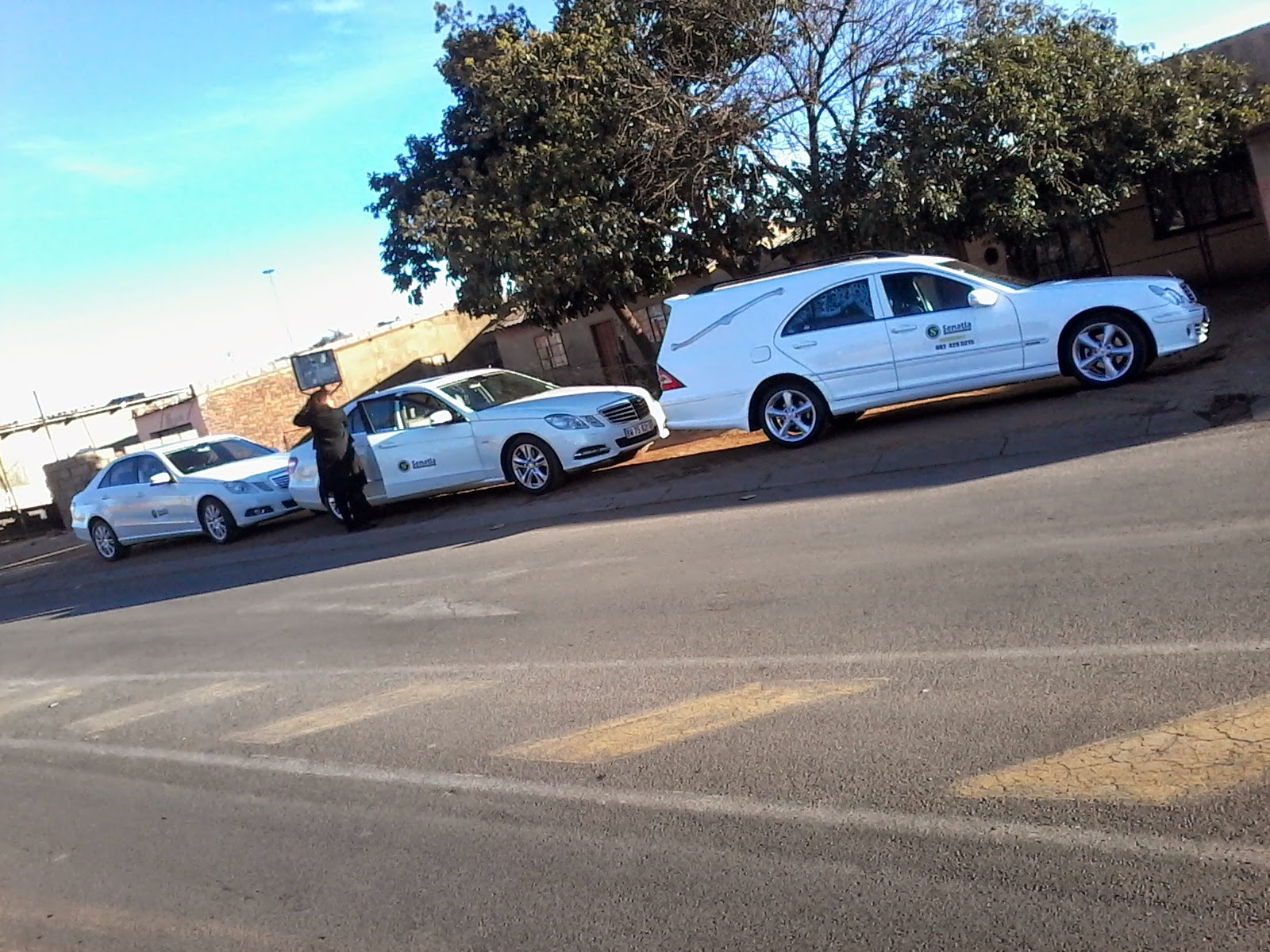 Senatla hearse and family car escorting a procession